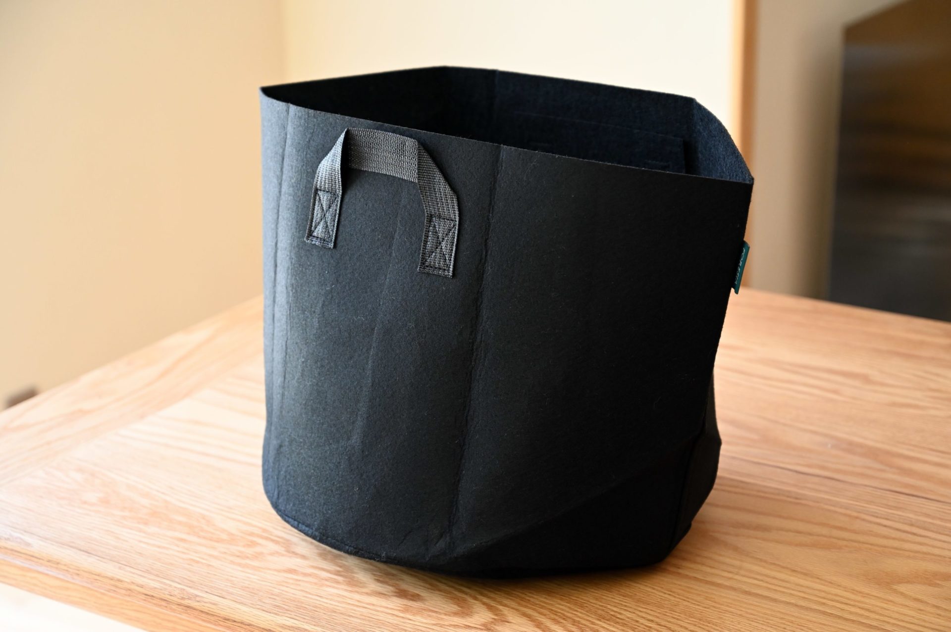 木のテーブルに置かれた黒色の不織布プランター