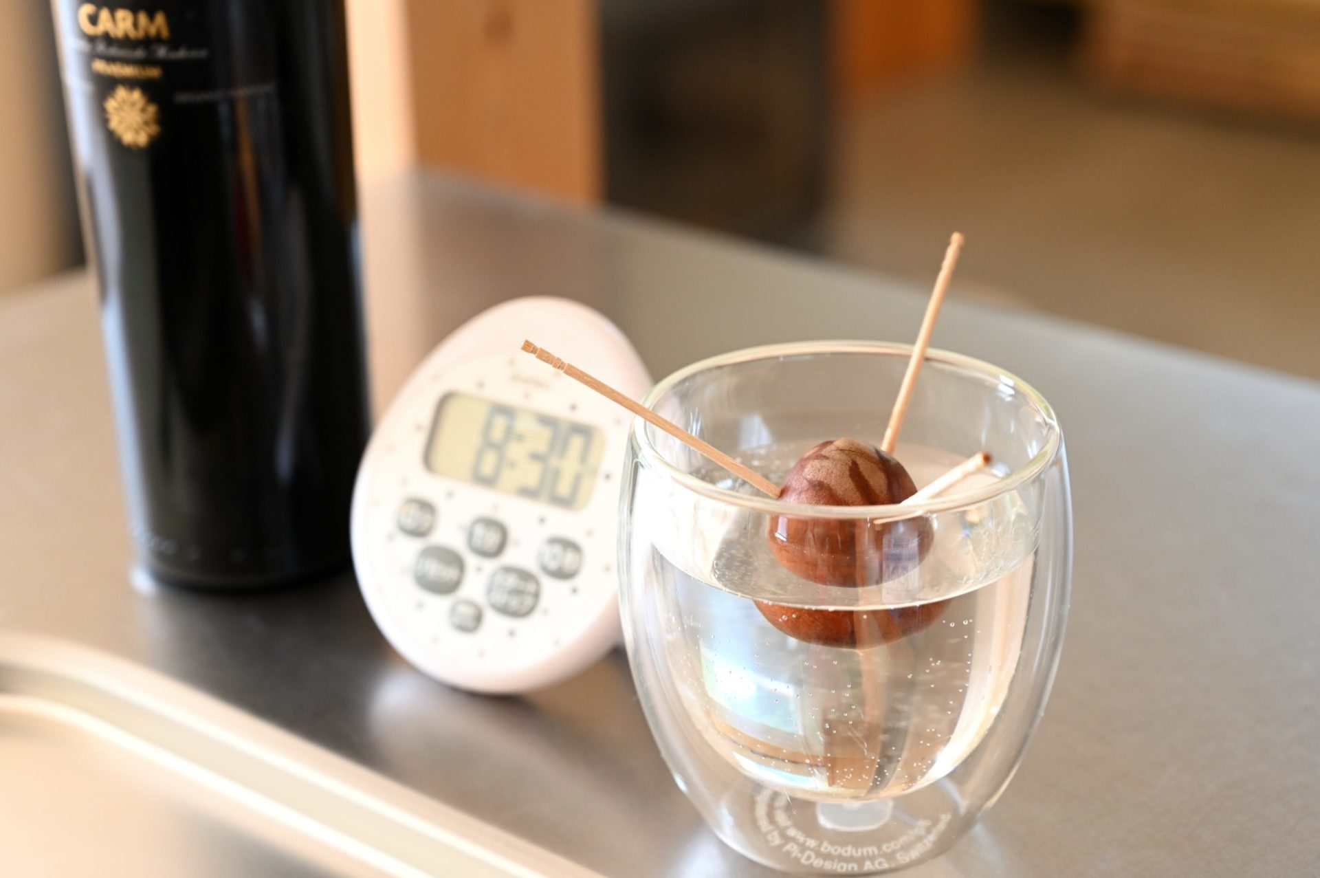 キッチンに並んでいるアボカドの再生栽培と時計とビン