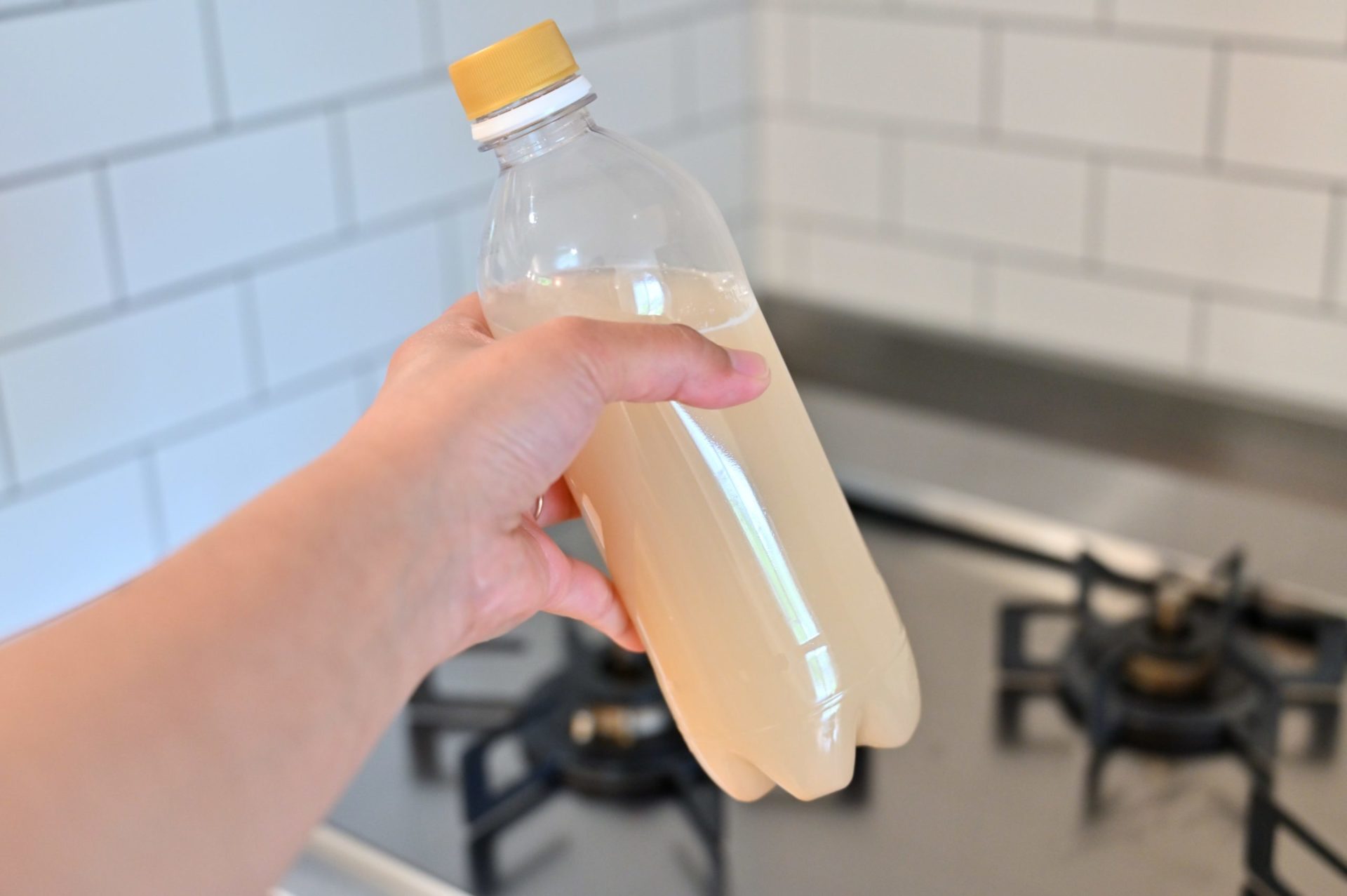 とぎ汁を入れていたペットボトルを手に持っている