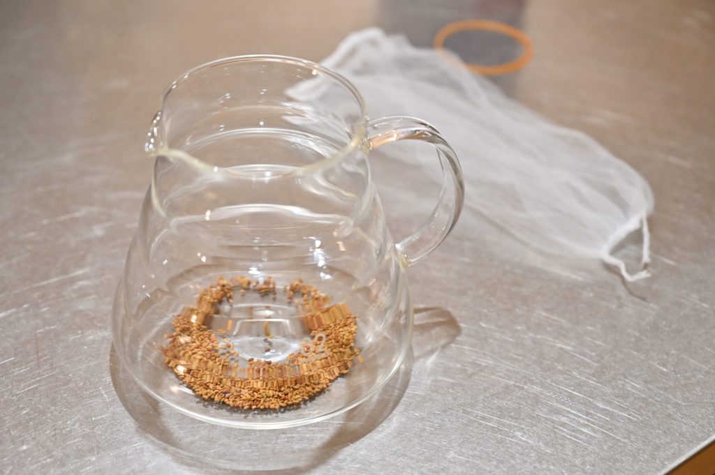 種が入ったガラス容器と水切りネットと輪ゴム