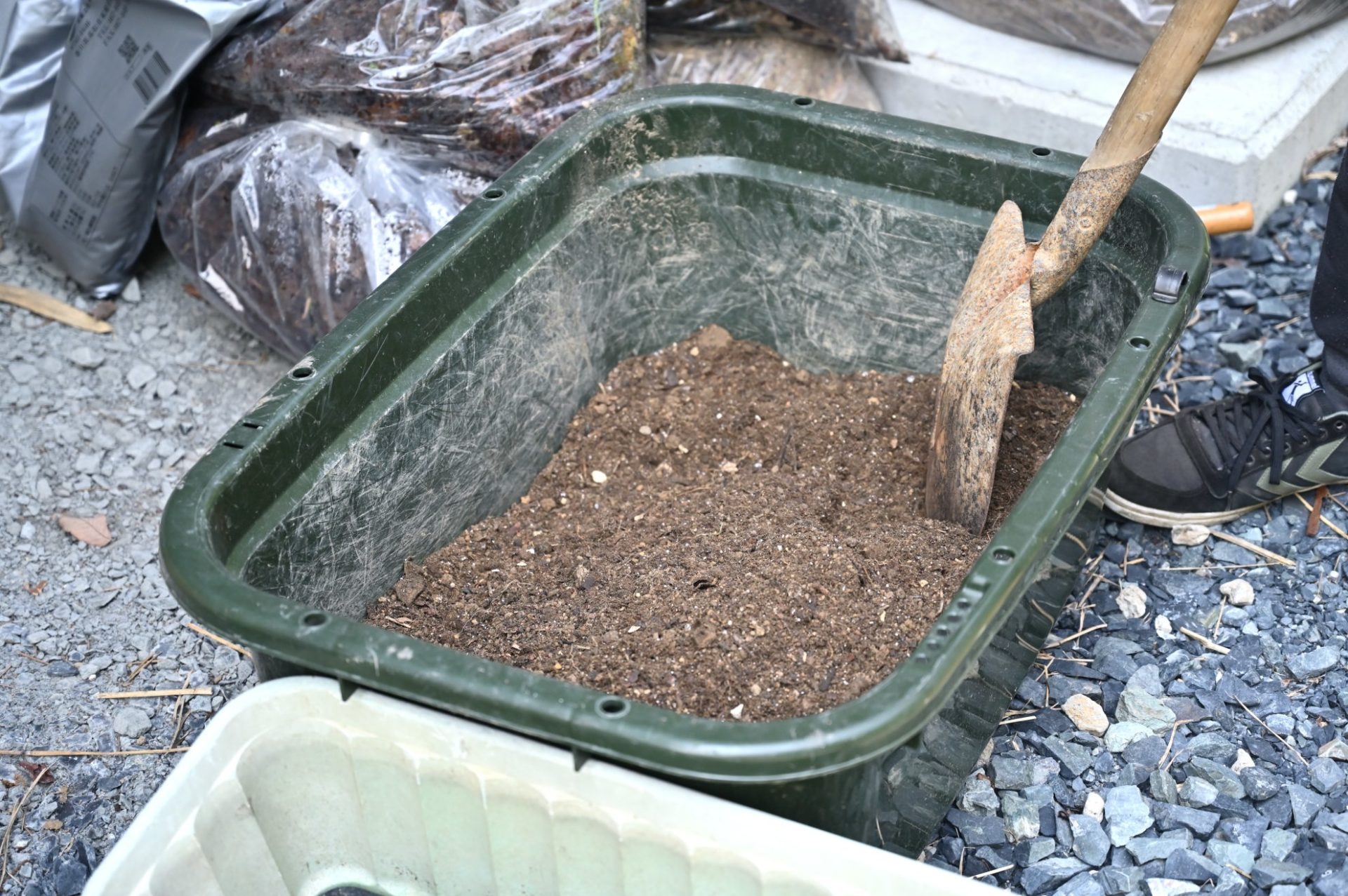 大きな容器に入っている土とスコップ