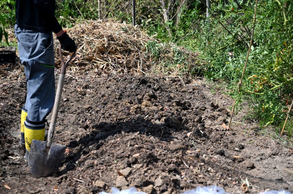 未完成の畝のそばに男性が立っている